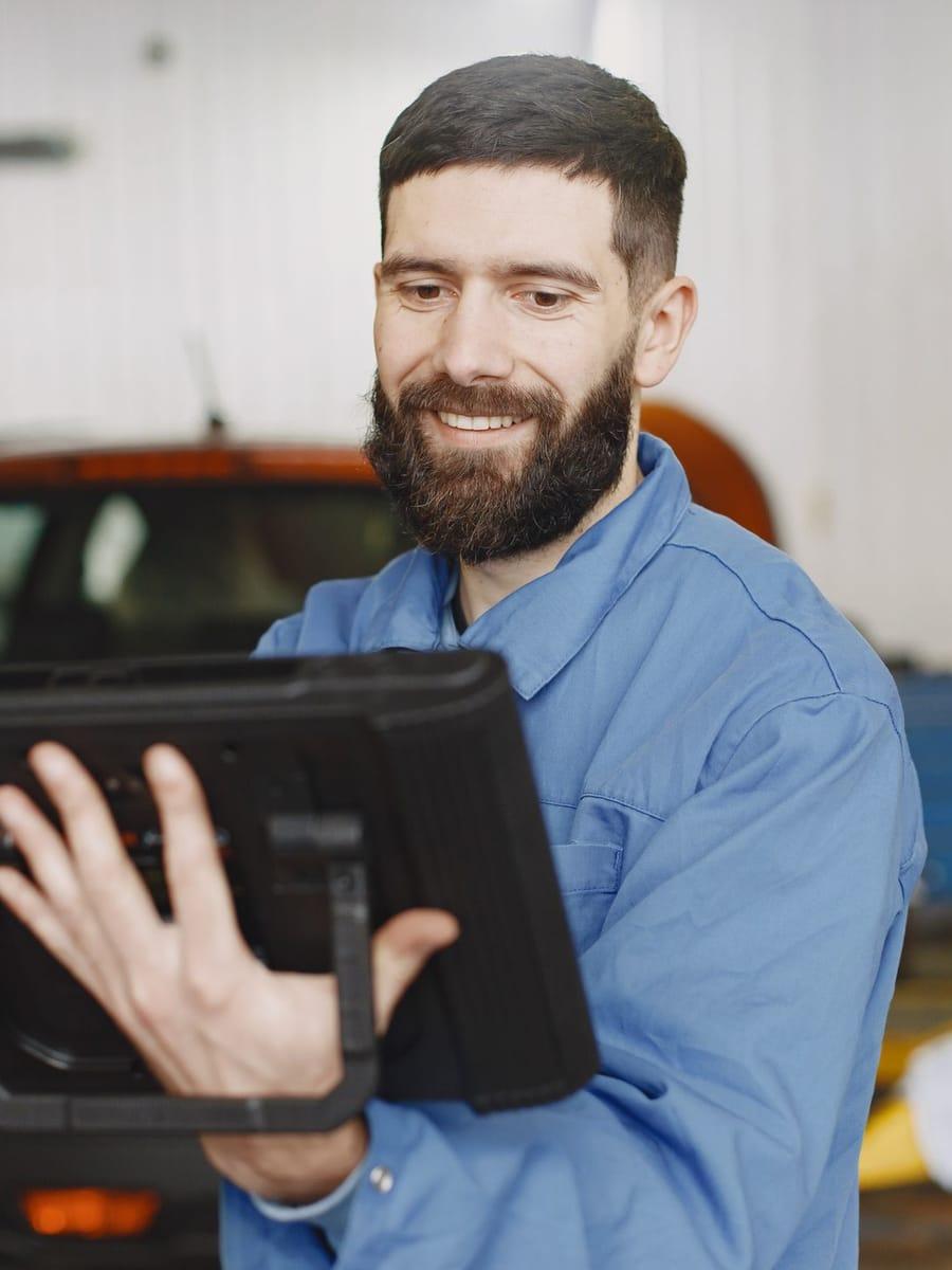 Garagehouder met tablet in de werkplaats