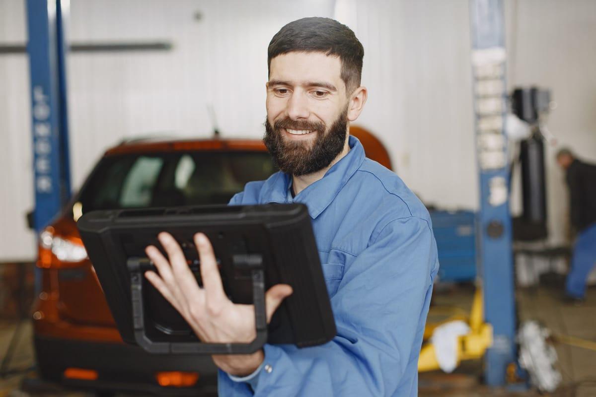 Garagehouder bekijkt een nieuwe boeking op zijn tablet