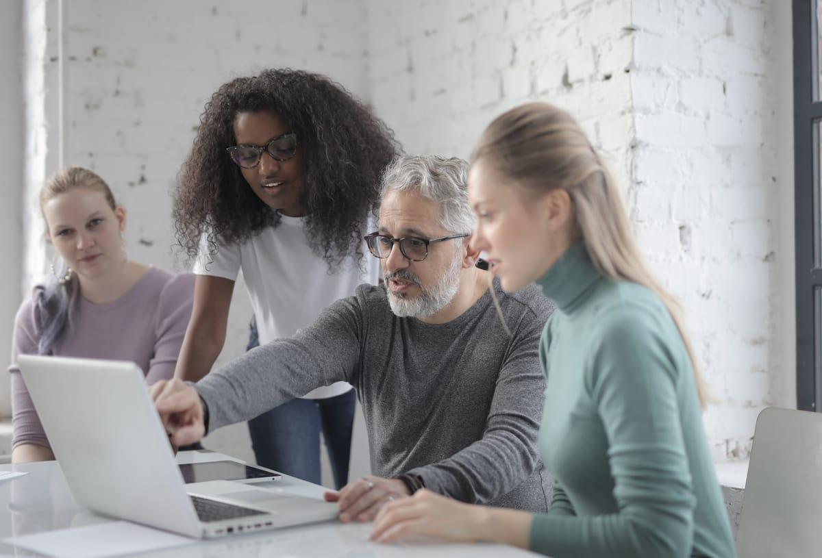 Collega's overleggen samen achter een laptop