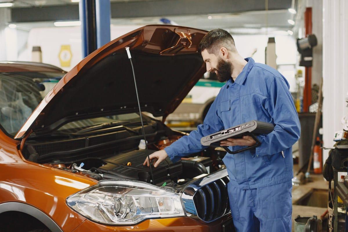 Monteur leest de foutcodes van een auto uit met een diagnosetablet
