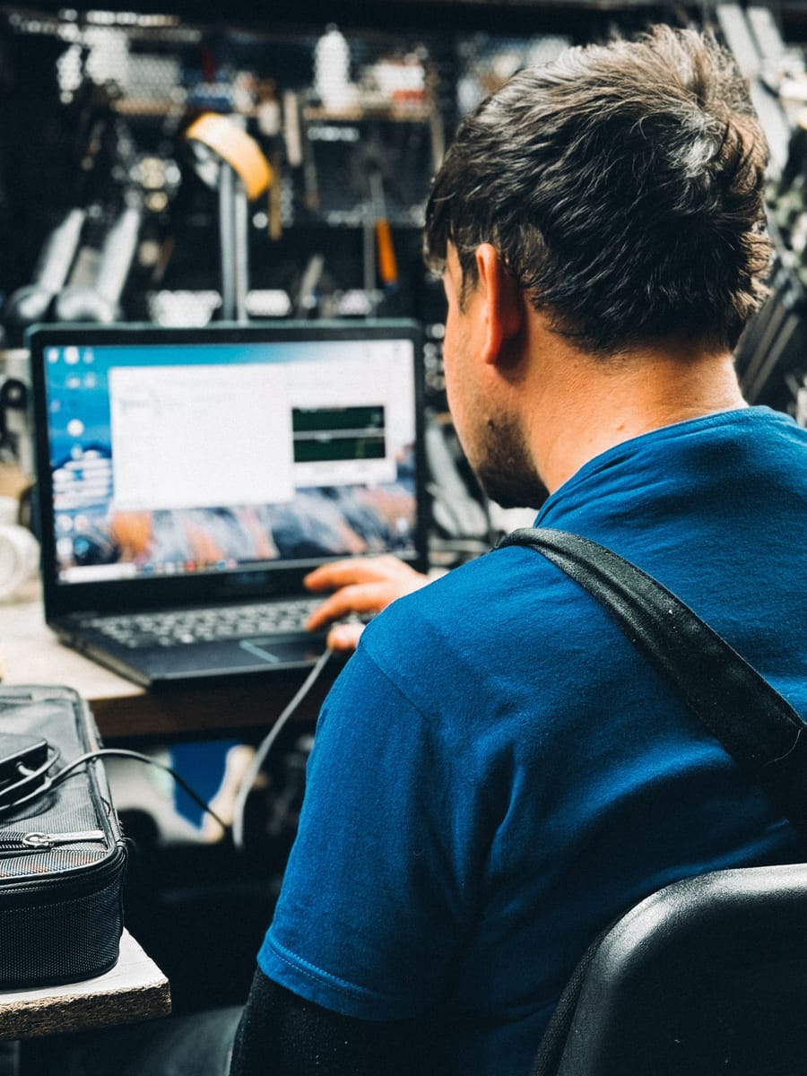 Garagehouder bekijkt zijn boekingen op de laptop in de werkplaats